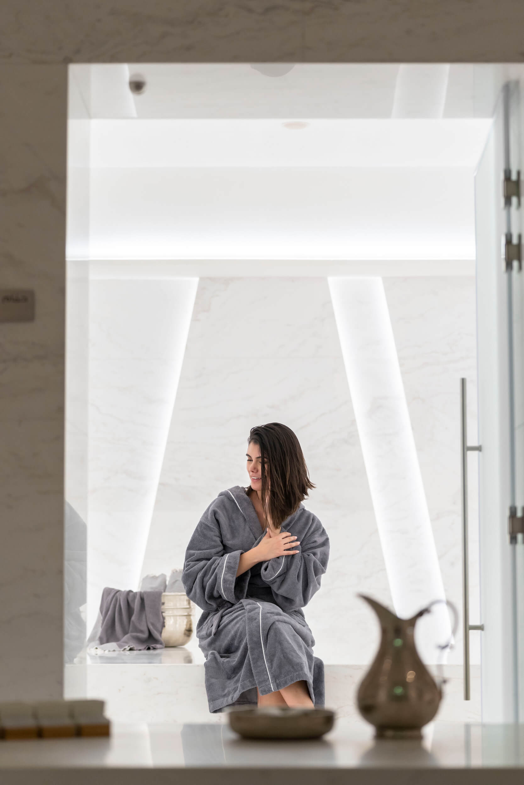 A women in a bath robe sat inside of the Nikki Beach spa